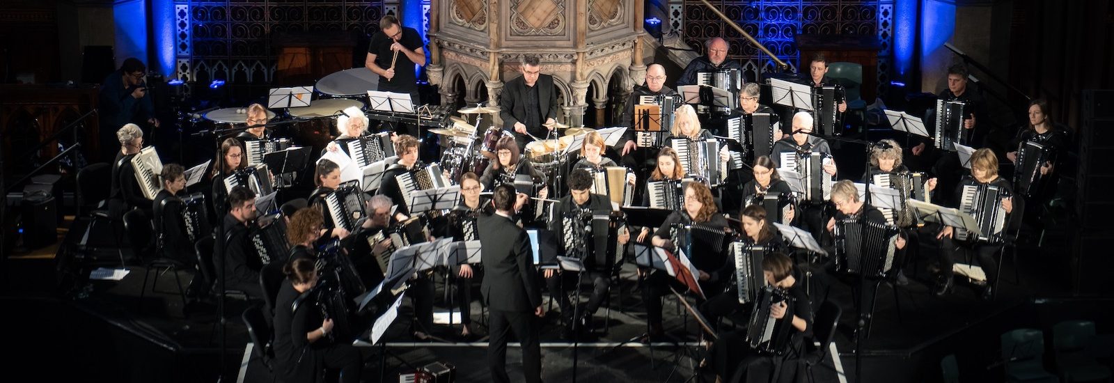 London Accordion Orchestra in concert at Union Chapel in front of blue lights
